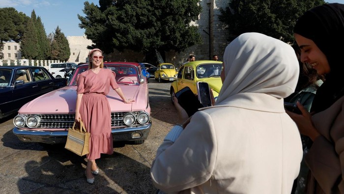 Pesona Mobil Klasik Bangkitkan Suasana Nostalgia Palestinians watch classic cars during a gathering organized by the Bethlehem municipality near the Church of the Nativity in Manger Square in Bethlehem in the Israeli-occupied West Bank, October 17, 2025. REUTERS/Mussa Qawasma