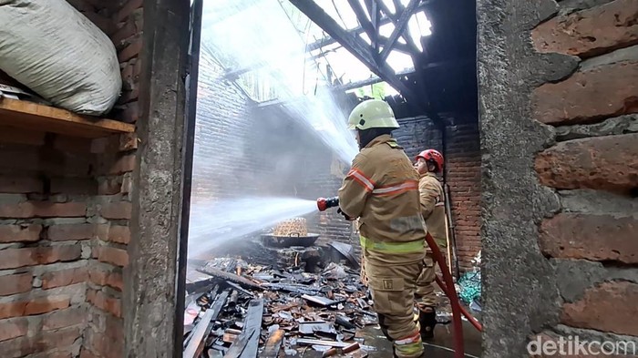 Petugas Pemadam Kebakaran (Damkar) Kabupaten Temanggung saat memadamkan kobaran api di pabrik kerupuk Dusun Krajan, Desa Sanggrahan, Kecamatan Kranggan, Rabu (22/10/2025).