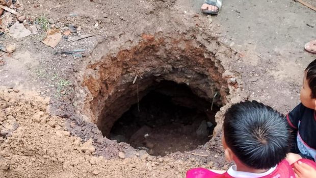 Petugas sedang meninjau lokasi lubang misterius yang tiba-tiba muncul di Desa Neglasari, Pamarican.