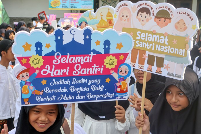 Sejumlah siswa madrasah membawa poster saat mengikuti pawai Hari Santri Nasional di Depok, Jawa Barat, Rabu (22/10/2025). Pawai anak  tersebut untuk memperingati Hari Santri Nasional 2025 dengan tema Mengawal Indonesia Merdeka, Menuju Peradaban Dunia. ANTARA FOTO/Yulius Satria Wijaya