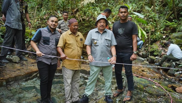 Foto: rombongan Bupati Nagan Raya Teuku Raja Keumangan berdiri di atas batu giok raksasa yang baru ditemukan. (Foto: Diskominfo Nagan Raya)