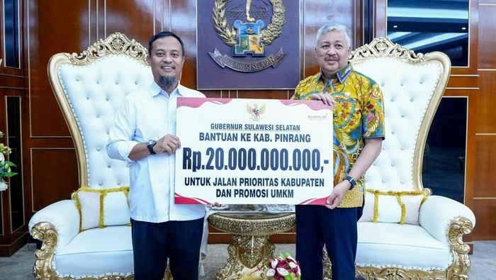 Gubernur Sulsel Andi Sudirman Sulaiman menyerahkan bantuan keuangan kepada Bupati Pinrang Andi Irwan Hamid.