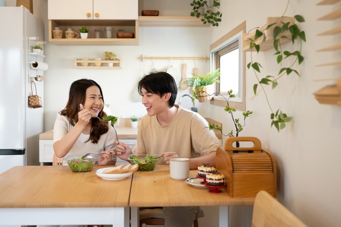 Happy young couple enjoying a healthy meal together in a minimalist kitchen.