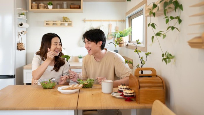 Happy young couple enjoying a healthy meal together in a minimalist kitchen.