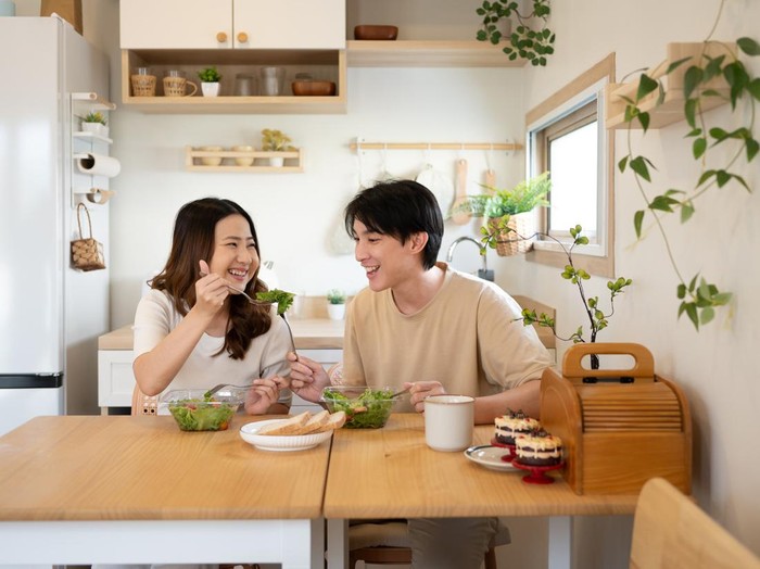 Happy young couple enjoying a healthy meal together in a minimalist kitchen.