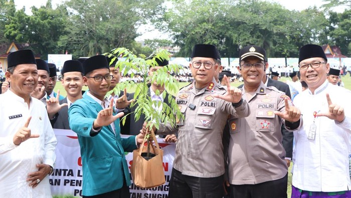 Kapolres Kuansing AKBP Ricky Pratidiningrat menanam pohon bersama santri.