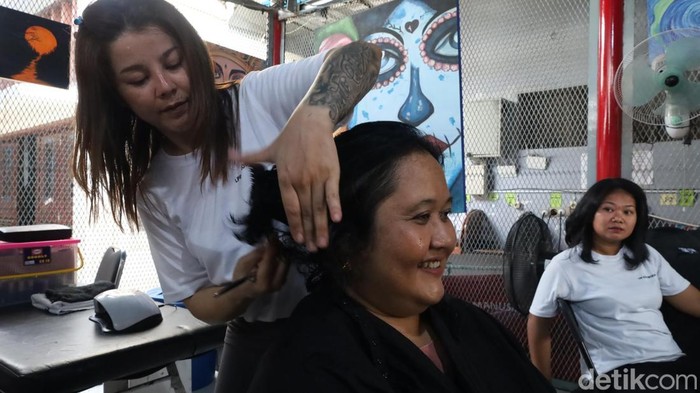 Kasarin saat sedang mengerjakan rambut salah seorang pelanggan di area dalam LPP Kerobokan, Rabu (22/10/2025). (Aryo Mahendro/detikBali).