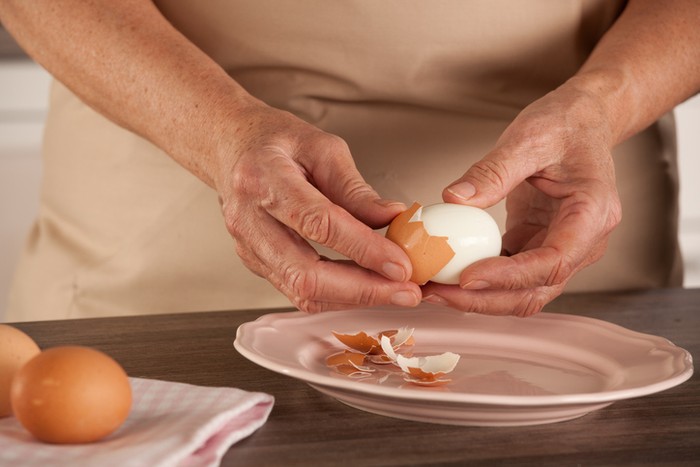Mengupas telur rebus