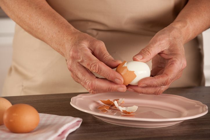 Mengupas telur rebus