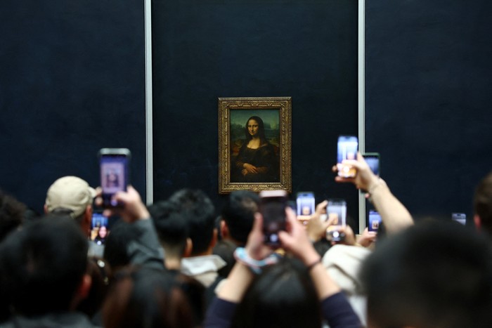 Visitors take pictures of the painting 