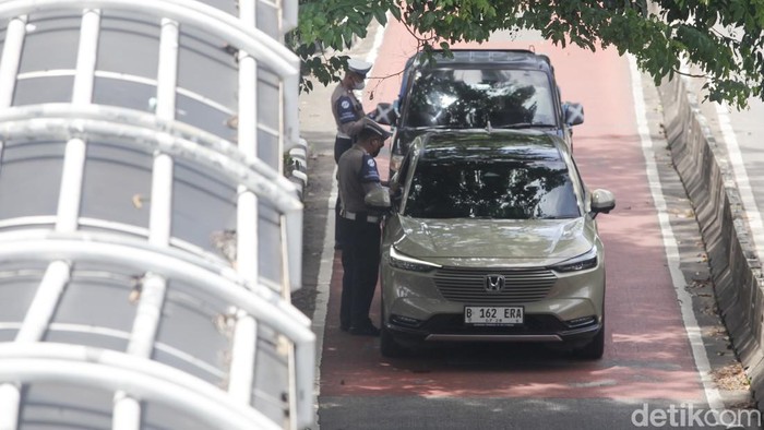 Priiit! Pengendara Bandel Terobos Busway Kena Tilang Polisi menindak pelanggar lalu-lintas yang menerobos jalur TransJakarta di Arteri Pondok Indah, Jakarta, Kamis (23/10/2025). Tilang secara manual masih diberlakukan di beberapa titik yang belum ada kamera tilang elektronik.