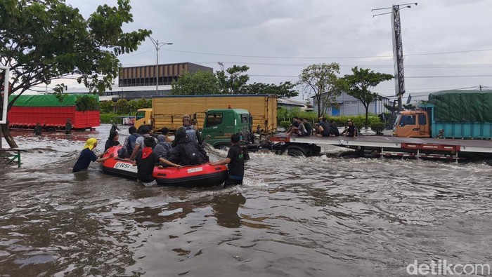 Banjir Semarang Relawan mahasiswa sedang membantu pasien turun dari perahu karet dan naik ke kursi roda di depan RSI Sultan Agung Semarang, Jumat (24/10/2025).