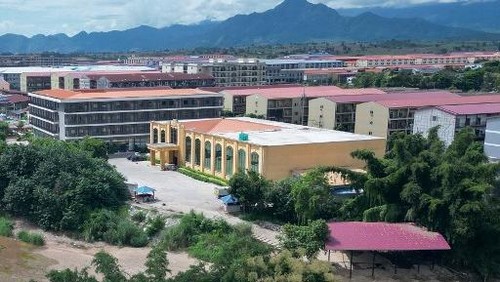 (FILES) This photo taken on September 17, 2025 shows advertisements for gambling sites and what appears to be Starlink satellite dishes on the roofs of buildings at KK Park complex in Myanmars eastern Myawaddy township, as pictured from Mae Sot district in Thailands border province of Tak. More than 600 people fled one of Myanmars most notorious scam centres and crossed into Thailand, a Thai provincial official told AFP on October 23, after a military raid on the compound. Sawanit Suriyakul Na Ayutthaya, deputy governor of Tak province on the Myanmar border, told AFP 677 people fled from the scam centre, known as KK Park, across the Moei river into Thailand as of the morning of October 23. (Photo by Lillian SUWANRUMPHA / AFP)