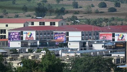 (FILES) This photo taken on September 17, 2025 shows advertisements for gambling sites and what appears to be Starlink satellite dishes on the roofs of buildings at KK Park complex in Myanmars eastern Myawaddy township, as pictured from Mae Sot district in Thailands border province of Tak. More than 600 people fled one of Myanmars most notorious scam centres and crossed into Thailand, a Thai provincial official told AFP on October 23, after a military raid on the compound. Sawanit Suriyakul Na Ayutthaya, deputy governor of Tak province on the Myanmar border, told AFP 677 people fled from the scam centre, known as KK Park, across the Moei river into Thailand as of the morning of October 23. (Photo by Lillian SUWANRUMPHA / AFP)