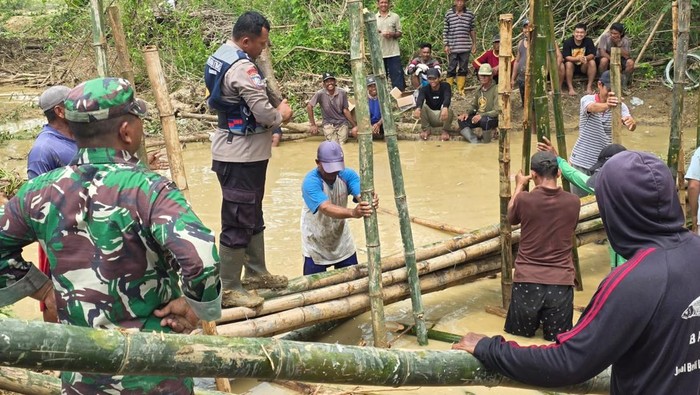 Personel Polsek Batangan dan stakeholder lainnya saat menangani tanggul yang jebol di Sungai Gandam di Kecamatan Batangan.