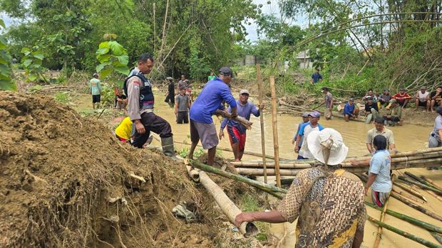 Personel Polsek Batangan dan stakeholder lainnya saat menangani tanggul yang jebol di Sungai Gandam di Kecamatan Batangan.