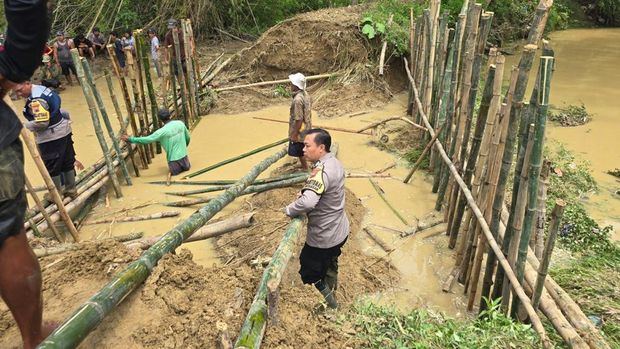 Personel Polsek Batangan dan stakeholder lainnya saat menangani tanggul yang jebol di Sungai Gandam di Kecamatan Batangan.