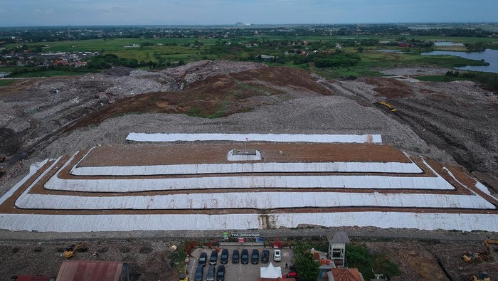 KLH Minta TPA Jabodetabek Tutup Tumpukan Sampah Pekerja berjalan di atas tumpukan sampah yang dilapisi dengan tanah dan geotextile di TPA Jatiwaringin KabupatenTangerang, Banten, Jumat (24/10/2025). Kementerian Lingkungan Hidup meminta seluruh TPA yang masih menggunakan sistem open dumping di wilayah Jabodetabek untuk segera melakukan capping atau penutupan tumpukan sampah guna mencegah pencemaran lingkungan dan penyebaran mikroplastik. ANTARA FOTO/Putra M. Akbar/foc.