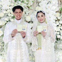 Sang mempelai pria, Moshe, memakai beskap putih dipadu sarung dan celana lebar berwarna senada. Beskap diberi hiasan bordir yang elegan. Foto: Instagram/@agusyudhoyono @ericktohir