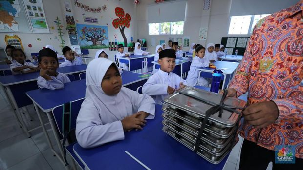 Petugas sekolah melalukan pembagian program (MBG) di Sekolah Dasar (SD) Angkasa 05 Halim, Jakarta, Jumat (24/10/2025). (CNBC Indonesia/Tri Susilo)