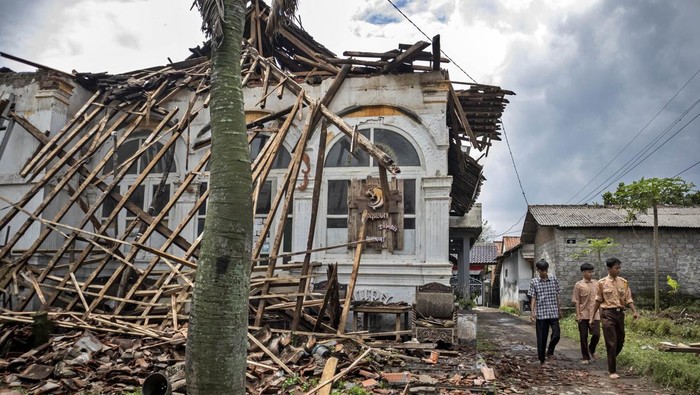 Pelajar berjalan di samping rumah berstatus objek diduga cagar budaya (ODCB) yang ambruk di Kampung Sukamaju, Batujajar, Kabupaten Bandung Barat, Jawa Barat, Jumat (24/10/2025). Rumah berarsitektur kolonial art deco yang berdiri sejak tahun 1850 dan sempat menjadi tempat berkumpul para pejuang pada masa revolusi fisik pasca proklamasi 1945 tersebut ambruk pada Kamis (23/10) akibat konstruksi bangunan serta atap yang lapuk. ANTARA FOTO/Abdan Syakura
