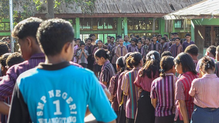 Sekolah Rusak Diterpa Material Gunung Lewotobi Sejumlah murid SMP Negeri 1 Wulanggitang berkegiatan dengan latar depan bangunan sekolah yang rusak di Flores Timur, Nusa Tenggara Timur, Senin (22/10/2025). Sejumlah bagian bangunan sekolah tersebut mengalami kerusakan akibat terus menerus terdampak material vulkanis dari Gunung Lewotobi Laki-laki sehingga kegiatan belajar mengajar setempat menjadi terganggu. ANTARA FOTO/Mega Tokan/app/rwa.