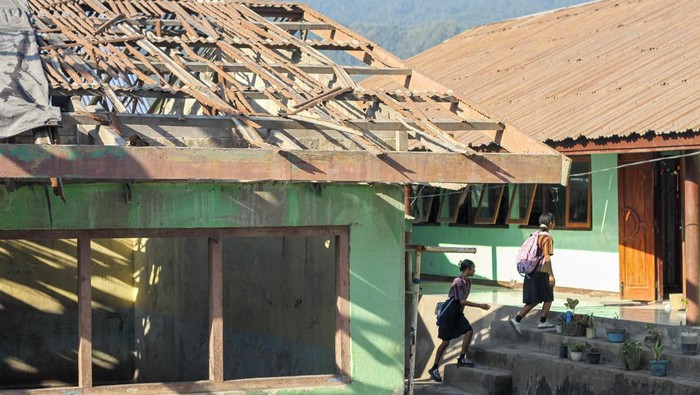 Sekolah Rusak Diterpa Material Gunung Lewotobi Sejumlah murid SMP Negeri 1 Wulanggitang berkegiatan dengan latar depan bangunan sekolah yang rusak di Flores Timur, Nusa Tenggara Timur, Senin (22/10/2025). Sejumlah bagian bangunan sekolah tersebut mengalami kerusakan akibat terus menerus terdampak material vulkanis dari Gunung Lewotobi Laki-laki sehingga kegiatan belajar mengajar setempat menjadi terganggu. ANTARA FOTO/Mega Tokan/app/rwa.