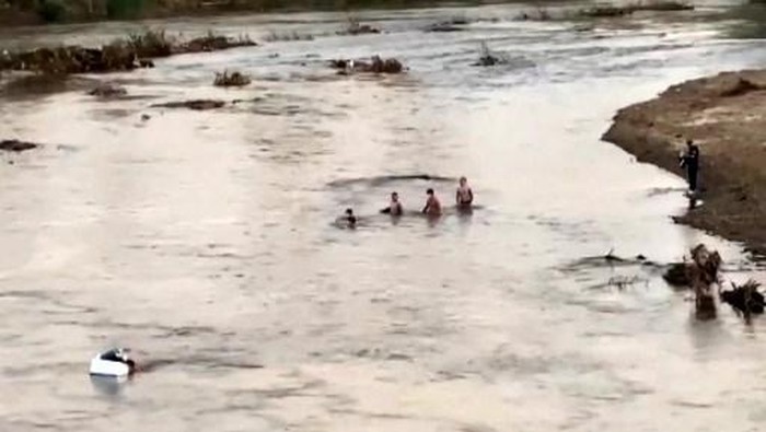 This screengrab from Thai PBS video footage taken in Mae Sot on October 22, 2025 and received by AFPTV on October 23, 2025 shows people crossing a section of the Moei river near KK Park in Myanmar (R) to Thailand. More than 600 people fled one of Myanmars most notorious scam centres and crossed into Thailand, a Thai provincial official told AFP on October 23, after a military raid on the compound. Sawanit Suriyakul Na Ayutthaya, deputy governor of Tak province on the Myanmar border, told AFP 