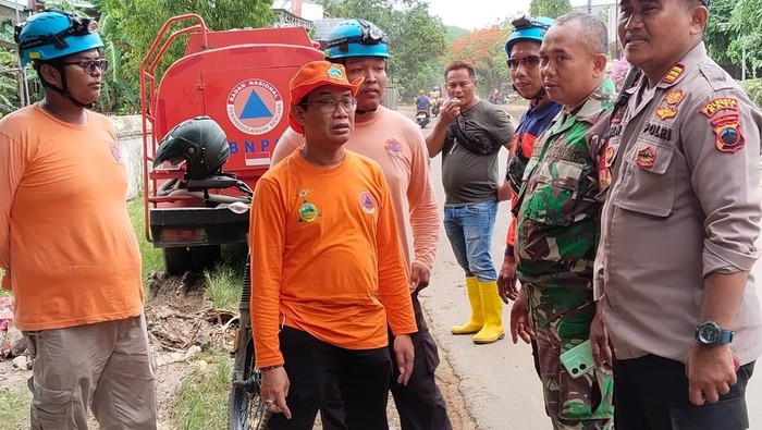 Banjir Pati BPBD bersama polisi dan TNI saat membersihkan material lumpur yang tersisa usai banjir di Desa Gadudero, Sukolilo, Pati, Sabtu (25/10/2025).