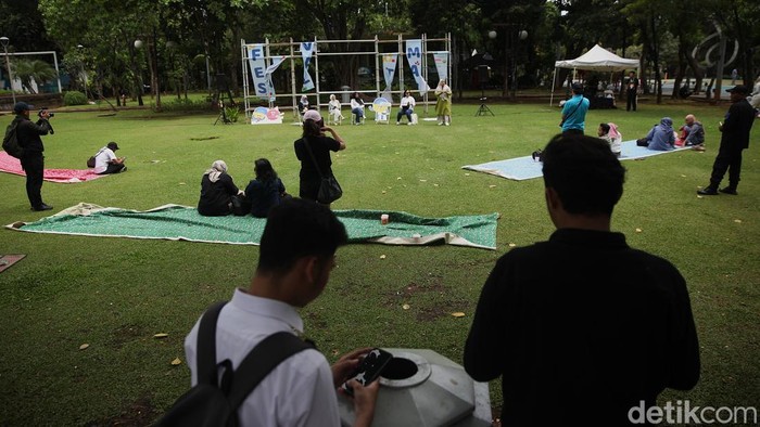 Peserta memperhatikan poster yang terpasang pada Festival Taman di Taman Menteng, Jakarta Pusat, Sabtu (25/10/2025). Beragam kegiatan dari berbagai komunitas, mulai dari workshop kreatif, diskusi, pertunjukan, hingga film screening dan walking tour.