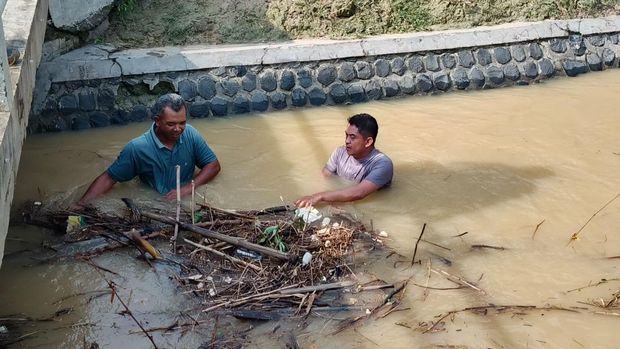 Njagani Jateng Anggota Polsek Batangan dan Polsek Sukolilo, Pati, bersama warga wilayah masing-masing melakukan aksi penanggulangan banjir. Foto diunggah Sabtu (25/10/2025).