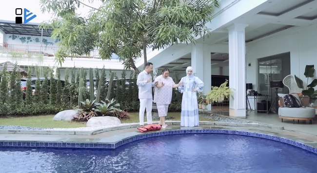 Daya tarik utama dari halaman rumah Irish Bella terletak pada kolam renang berukuran besar. Bila biasanya kolam berada di halaman belakang rumah, di sini kolam tepat berada di balik gerbang. (Foto: YouTube/Has Entertainment)
