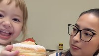 Hmmm enak, kata Kamari pada gigitan pertama. Terlihat donat ini berukuran lumayan besar, lengkap dengan taburan gula bubuk. Foto: TikTok jennifer.coppen