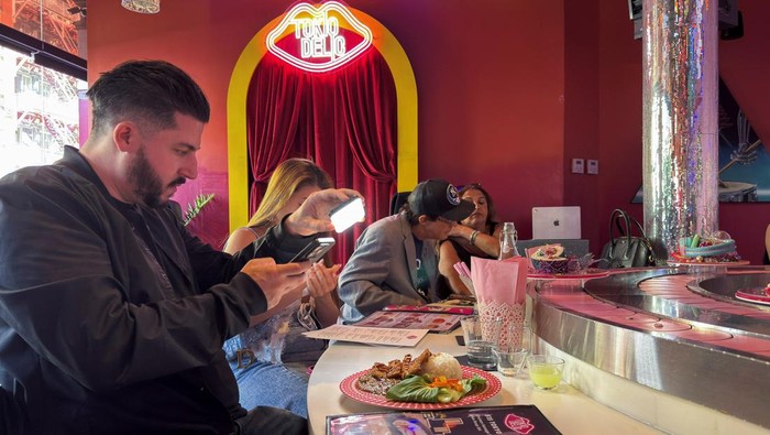 A visitor photographs food at the Tokiodelic cafe, in New York, U.S., October 17, 2025. REUTERS/Roselle Chen