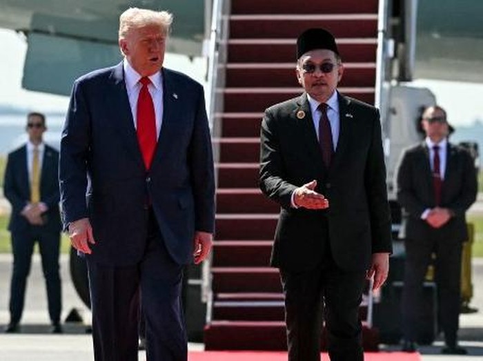 US President Donald Trump (L) speaks with Malaysias Prime Minister Anwar Ibrahim (R) as he walks from Air Force One upon arrival at Kuala Lumpur International Airport in Kuala Lumpur on October 26, 2025. US President Donald Trump arrived in Malaysia on October 26 on the first leg of an Asian tour that will include high-stakes trade talks with Chinese counterpart Xi Jinping. (Photo by ANDREW CABALLERO-REYNOLDS / AFP)