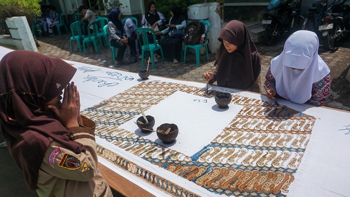 Sejumlah pelajar membatik di atas kain sepanjang 116 meter di Kampung Batik Pesindon, Pekalongan, Jawa Tengah, Sabtu (25/10/2025). Kampung Batik Pesindon menggelar kegiatan membatik dengan menggunakan pewarna alam bersama warga, pelajar SD dan SMP yang bersamaan dengan peringatan 16 tahun diakuinya batik sebagai Warisan Budaya Tak Benda  oleh UNESCO, serta perwujudan semangat generasi muda menyambut Hari Sumpah Pemuda pada 28 Oktober mendatang. ANTARA FOTO/Harviyan Perdana Putra/rwa.