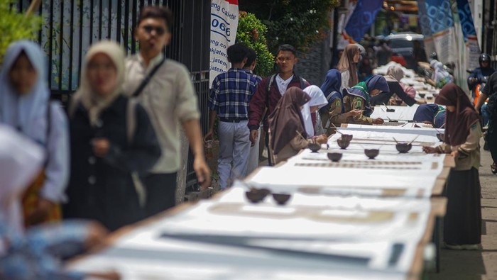 Sejumlah pelajar membatik di atas kain sepanjang 116 meter di Kampung Batik Pesindon, Pekalongan, Jawa Tengah, Sabtu (25/10/2025). Kampung Batik Pesindon menggelar kegiatan membatik dengan menggunakan pewarna alam bersama warga, pelajar SD dan SMP yang bersamaan dengan peringatan 16 tahun diakuinya batik sebagai Warisan Budaya Tak Benda  oleh UNESCO, serta perwujudan semangat generasi muda menyambut Hari Sumpah Pemuda pada 28 Oktober mendatang. ANTARA FOTO/Harviyan Perdana Putra/rwa.