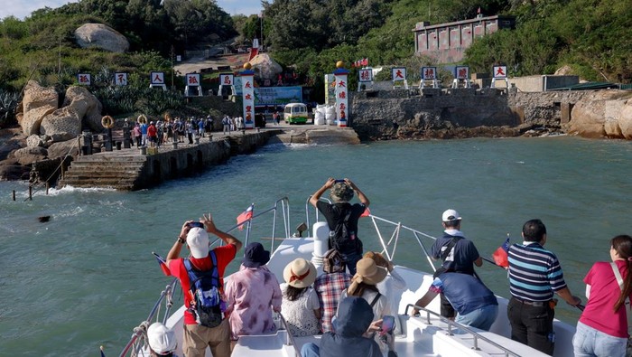 Potret Pulau Dadan, Benteng Militer yang Kini Menyambut Wisatawan Tourists gather at the port and entrance of Dadan, with China's Xiamen visible in the background, on Dadan Island, in Kinmen, Taiwan, October 18, 2025. REUTERS/Ann Wang