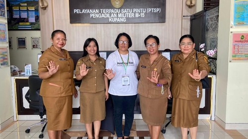 Ibu almarhum Prada Lucky Chepril Saputra Namo, Sepriana Paulina Mirpey, berfoto dengan petugas dari UPTD PPA NTT sebelum bersaksi atas kasus kematian anaknya di Pengadilan Militer III-15 Kupang, Senin (27/10/2025). (Simon Selly/detikBali)