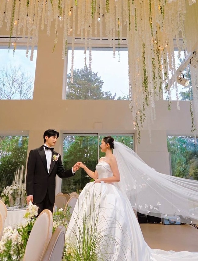 Di hari bahagianya, Kim Ga Eun tampil anggun mengenakan ball gown berwarna putih dengan veil panjang. Sementara sang aktor memakai setelan tuxedo hitam klasik dengan dasi kupu-kupu. Foto: Instagram