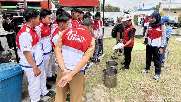 Pertamina Patra Niaga Sumbagsel Siswa SMK di Palembang saat memperhatikan pengecekan kualitas BBM di salah satu SPBU.