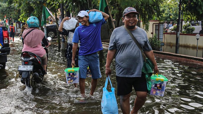 Warga Terdampak Banjir di Semarang Terima Bantuan Logistik Sejumlah warga korban banjir membawa bantuan berupa paket sembako di kawasan Kantor Kecamatan Genuk, Semarang, Jawa Tengah, Senin (27/10/2025). Pemerintah Provinsi Jawa Tengah menyalurkan bantuan untuk warga terdampak banjir di Semarang senilai Rp410,4 juta yang terdiri dari logistik permakanan dan non-makanan termasuk beras 2,5 ton serta obat-obatan sebagai upaya meringankan beban sekaligus memberi semangat kepada korban banjir. ANTARA FOTO/Makna Zaezar
