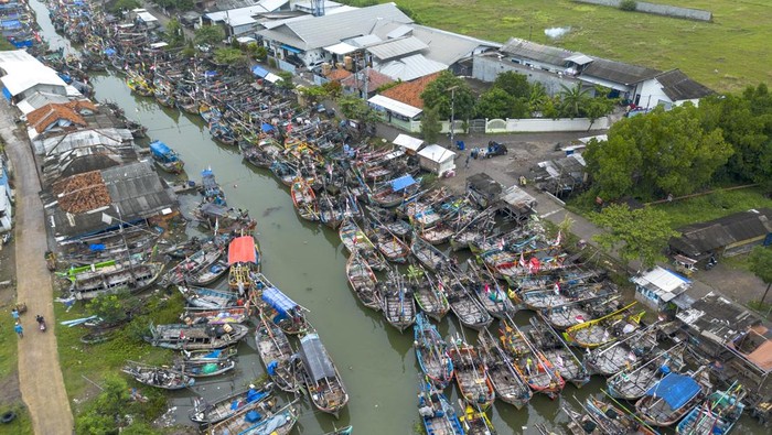 Foto udara perahu nelayan bersandar di muara sungai Limbangan,  Juntinyuat, Indramayu, Jawa Barat, Selasa (28/10/2025). Nelayan setempat mengaku sudah tidak melaut sejak seminggu terakhir akibat cuaca buruk berupa gelombang tinggi dan angin kencang di perairan Laut Jawa. ANTARA FOTO/Dedhez Anggara/bar