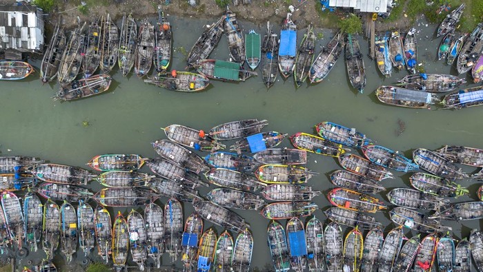 Gelombang Tinggi Bikin Nelayan Indramayu Tak Berani Melaut Foto udara perahu nelayan bersandar di muara sungai Limbangan, Juntinyuat, Indramayu, Jawa Barat, Selasa (28/10/2025). Nelayan setempat mengaku sudah tidak melaut sejak seminggu terakhir akibat cuaca buruk berupa gelombang tinggi dan angin kencang di perairan Laut Jawa. ANTARA FOTO/Dedhez Anggara/bar