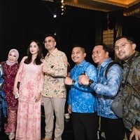 Nagita tampil simpel dengan setelan dress warna pink. Atasannya dilengkapi dengan luaran menerawang dengan detail bunga yang memberikan kesan feminin pada tampilannya. Ia kemudian memadukannya dengan celana senada bermotif yang berpotongan lebar. Foto: Instagram/@raffinagita1717