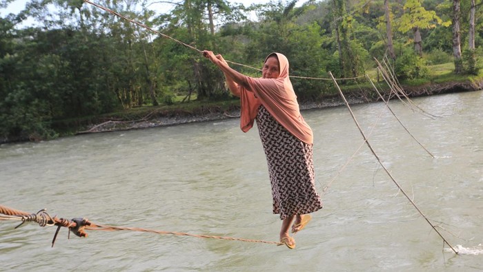 Potret Warga Bertaruh Nyawa Seberangi Sungai Lewat Jembatan Tali Sejumlah warga melintasi jembatan tali yang terbuat dari kabel listrik penghubung Desa Canggai dengan Desa Keutambang Kecamatan Pante Ceureumen, Aceh Barat, Aceh, Selasa (28/10/2025). Sebagian warga di kawasan itu masih menggunakan jembatan tali sebagai sarana penyeberangan untuk mempersingkat jarak tempuh ke desa tetangga menjadi sekitar 700 meter dari pada menggunakan jalur alternatif dan harus memutar sekitar 2,5 km hingga 4 km. ANTARA FOTO/Syifa Yulinnas/foc.