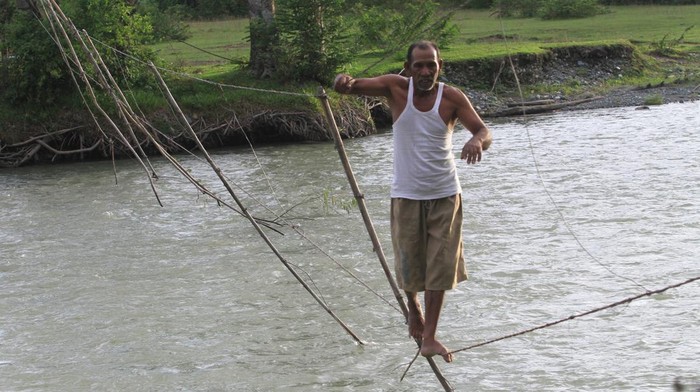 Sejumlah warga melintasi jembatan tali yang terbuat dari kabel listrik penghubung Desa Canggai dengan Desa Keutambang Kecamatan Pante Ceureumen, Aceh Barat, Aceh, Selasa (28/10/2025). Sebagian warga di kawasan itu masih menggunakan jembatan tali sebagai sarana penyeberangan untuk mempersingkat jarak tempuh ke desa tetangga menjadi sekitar 700 meter dari pada menggunakan jalur alternatif dan harus memutar sekitar 2,5 km hingga 4 km. ANTARA FOTO/Syifa Yulinnas/foc.