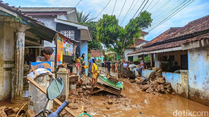 Warga Kampung Tugu saling membantu mengevakuasi motor dan perabot rumah tangga yang rusak akibat terendam lumpur. Banyak warga memilih tetap bertahan di rumah pascabanjir Warga Kampung Tugu saling membantu mengevakuasi motor dan perabot rumah tangga yang rusak akibat terendam lumpur. Banyak warga memilih tetap bertahan di rumah pascabanjir