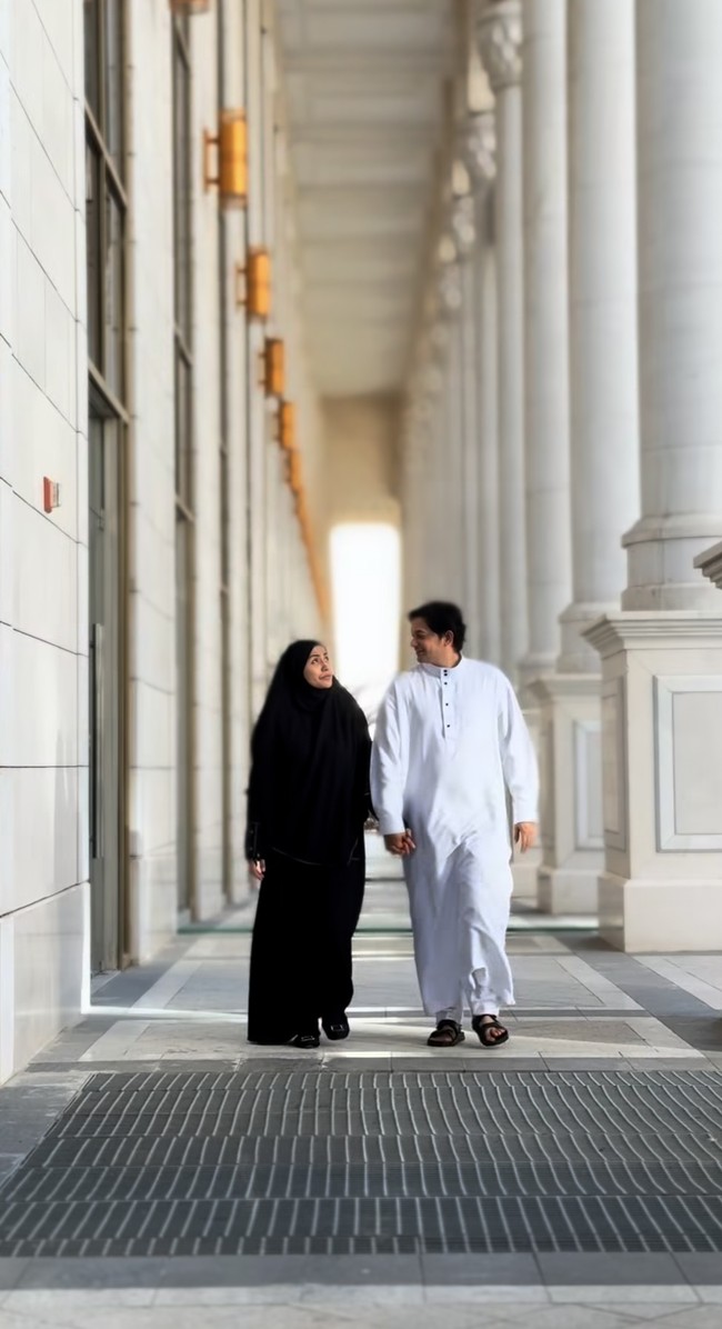 Violentina tampil syar’i serba hitam, sementara Andrew mengenakan gamis pria warna putih. Keduanya selalu bergandengan tangan seolah tak terpisahkan. Foto: Instagram/@andrewandika