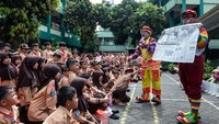 Badut menunjukkan koran kepada siswa dalam kegiatan Dunia Literasi Anak (Durian) di SDIT Gunung Jati, Cibodas, Kota Tangerang, Rabu (29/10/2025).  ANTARA FOTO/Putra M. Akbar